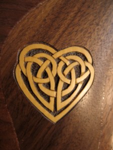 Celtic knotwork heart carved and inlain into a custom Raphael26  Claro Walnut Therapy harp. Made of Boxwood